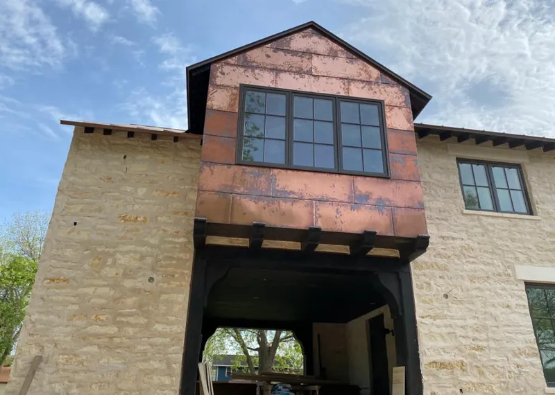 Copper metal panel facade on a stone building for Roof Repair in Dixon